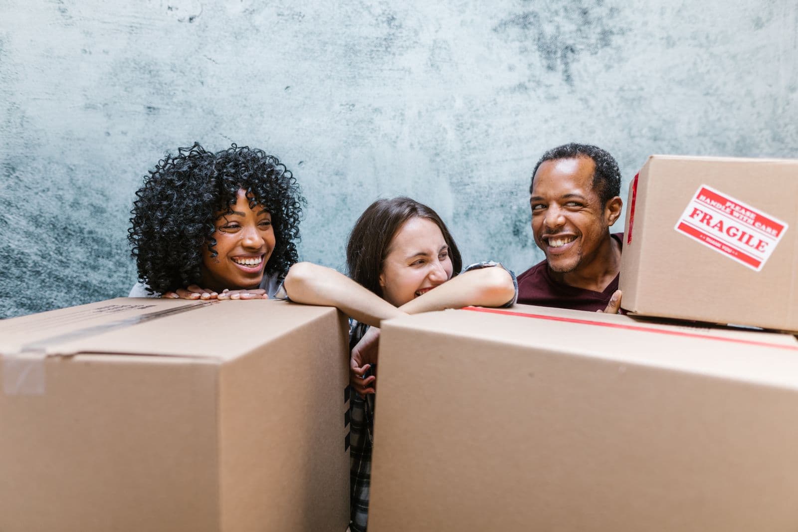Happy customers laughing together while packing moving boxes